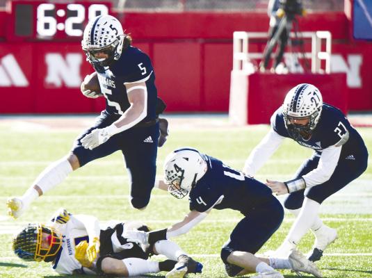 CENTRAL VALLEY’S Grady Kelly hurdles a Riverside defender on his way upfield during Monday’s Class D-2 championship game in Lincoln. Kelly earned ninety-two yards on the turf at Memorial Stadium against Riverside. Photos by Jordan Coslor