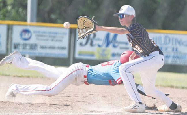 ST. PAUL’S TY HAAK attempts to tag out a baserunner in the St. Paul Juniors’ first-round game against Pender. Haak went one-for-three at the plate in the game, scoring two runs and driving in another. Photos by Michael Happ
