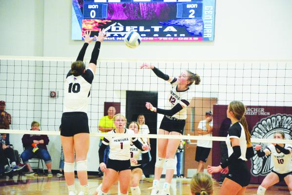 CENTURA senior Syndey Davis hits the ball past a Clarkson/Leigh defender during Saturday’s C2-8 District Final played at Centura High School. Davis led the locals’ attack with nineteen kills in the threeset match. (Monte Steele)
