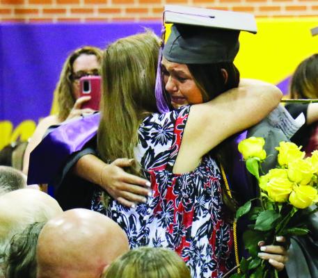 ELBA GRADUATE Alexis Berggren embraces a loved one during Saturday afternoon’s graduation ceremony at Elba High School. (Haley Spotanski)