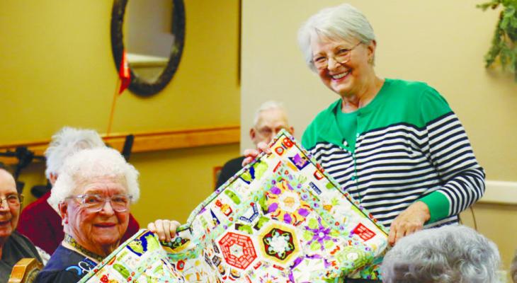 ANNA MARY SMITH was all smiles after she won a quilt in a raffle during the St. Paul Country Quilters quilt show at Matelyn Retirement Community on Monday afternoon. Marilyn Schmaljohn presented the quilt to Smith. Photo by Michael Rother