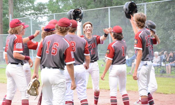 BRYCE GORECKI was swarmed by his teammates on Sunday after he hit a home run in the first inning of DCB’s game against Shelton/Gibbon. Gorecki had three hits in the game. (Monte Steele)