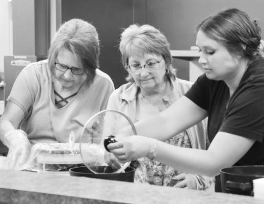 VOLUNTEERS with the Sts. Peter and Paul Council of Catholic Women, including Barb Sack, Charlene Potter, and Tonya Anderson, work to prepare meals during Lunch Bunch last Tuesday. Photos by Michael Rother