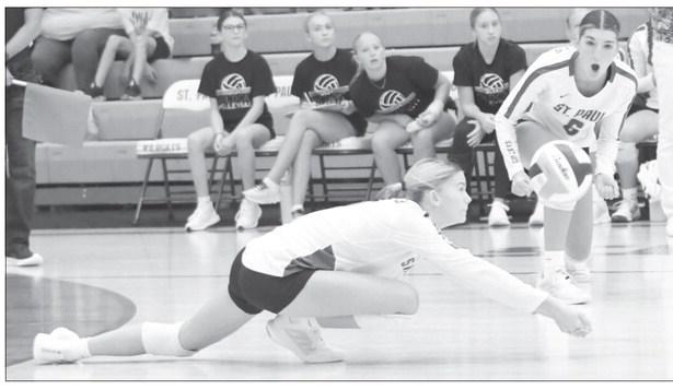 PIEPYR KLINGINSMITH digs up a shot during last Thursday night’s season opener at St. Paul High School while Aubree Fitzgerald looks on. The Wildcats fell to the David City Scouts 3-0. Photos by Michael Happ