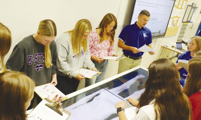 KURT HARDERS leads members of his college credit anatomy class—including Anistyn Knapp, Avery Hansel, Katie Oakley, and Ella Petersen—through an examination of “Hans” last week. Photo by Michael Rother