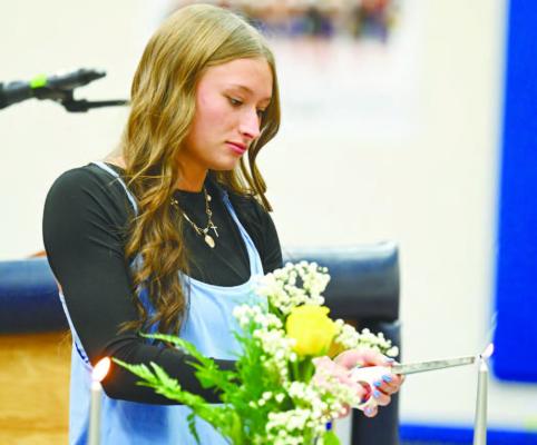 ST. PAUL NATIONAL HONOR SOCIETY Secretary Kamden Sack lights a candle during last week’s induction ceremony at St. Paul High School. Twenty-two new students were inducted into the National Honor Society at St. Paul last week. Photos by Michael Happ