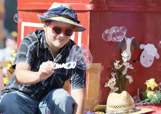BRAYDEN WOLINSKI created bubbles on the back of the Wolinski family’s float on Saturday morning. The float, which was in memory of Ernie and Yvonne Wolinski, featured the theme “Farming: A Slice of the Good Life” and placed second in the float division. (Michael Happ)