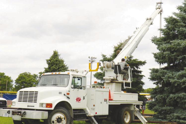 CREWS WITH THE CITY OF ST. PAUL worked to install a new flagpole at Grover Cleveland Alexander Field in St. Paul last Monday afternoon. The new flagpole stands thirty-five feet tall. Photos by Michael Rother