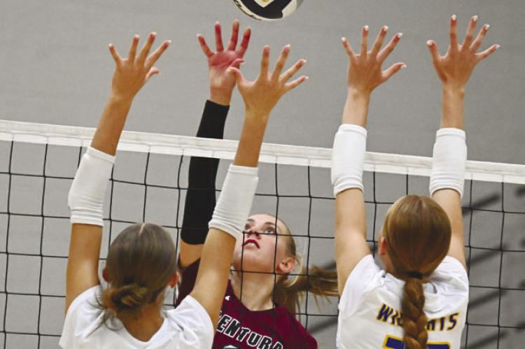 CENTURA’S ELLA FRANCL rises above St. Paul’s Adalynn Wells and Ariel Wells during the second set of last Tuesday’s match between the Centurions and the Wildcats. Photo by Michael Happ