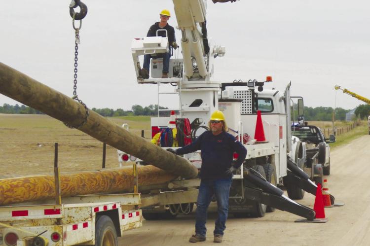 CREWS with Howard Greeley Rural Public Power District—including Cody Kaczor and Robert Svoboda—work to repair power infrastructure in southern Howard County following last month’s destructive tornado. Courtesy Photo