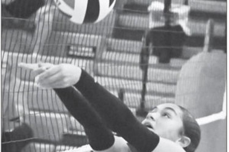BELLE TAUKIUVEA passes the ball over the net during the final set of last Tuesday’s match against Doniphan-Trumbull. Photo by Michael Happ