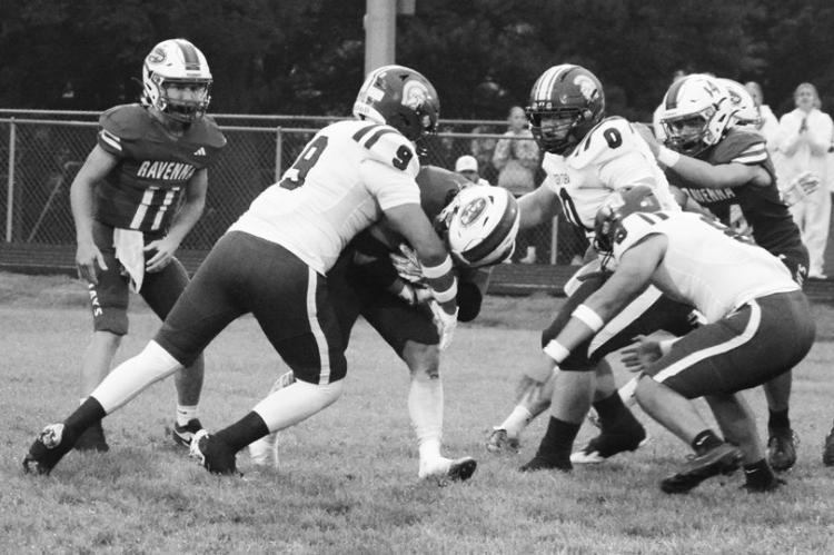 CENTURA DEFENDERS Luis Flores, Jayce Campbell, and Christian Iron Horse work to bring down a Ravenna ball carrier on Friday night. Photos by Monte Steele
