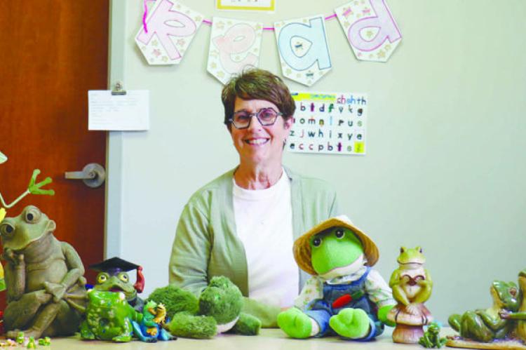 KELLIE SEWARD sits at a desk in her room at St. Paul Elementary School surrounded by just a few of the frogs she has been given by her students, their families, and her colleagues. When she started teaching forty-one years ago, the retiree had been asked to choose a theme for her classroom. She chose frogs, and the association has stuck. Photo by Michael Rother