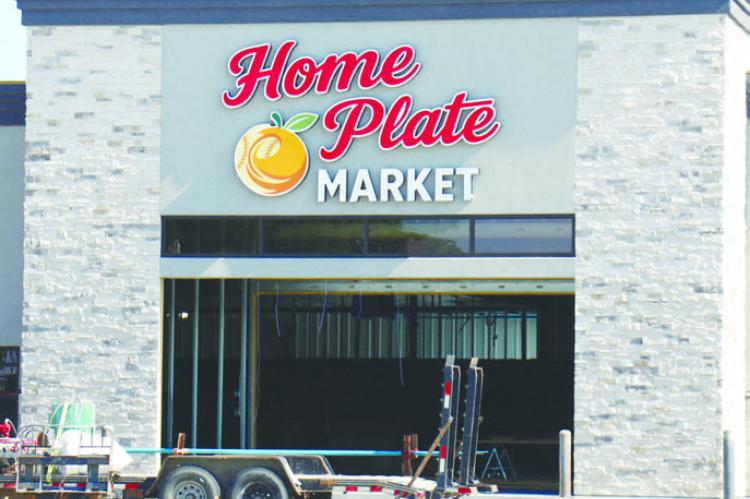 WORKERS officially put a name to St. Paul’s new grocery store over the weekend, as signage was hung on the future site of Home Plate Market on the corner of Second and O streets in St. Paul. The market, which is set to open late this fall, went ver tical at the start of the year. Crews have been working on the project since last fall. Photo by Michael Rother