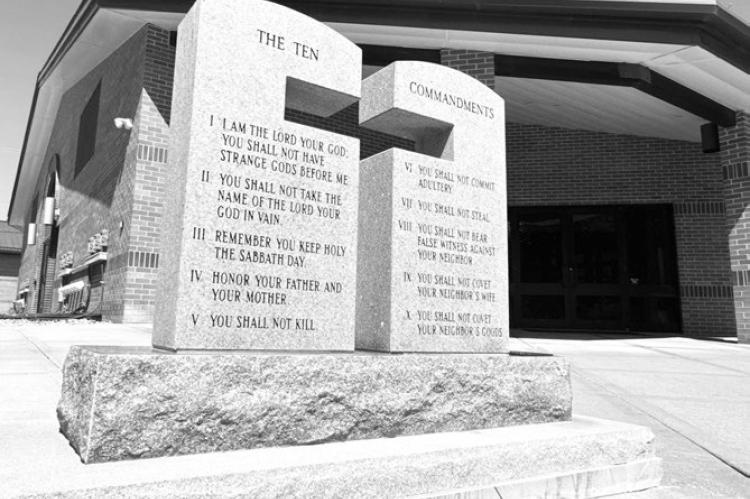 A STONE MONUMENT inscribed with the Ten Commandments and the Beatitudes was recently placed at the east entrance of Sts. Peter and Paul Catholic Church in St. Paul. The stone was donated by the Mel Kosmicki family and was dedicated following the 10:00 a.m. Mass on Sunday, May 24th. Photo by Michael Happ