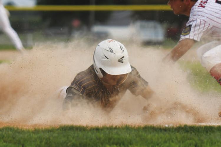 COLBY WOOD beats the tag, sliding safely into home plate after a wild pitch in the first inning of St. Paul’s second game with Ord.