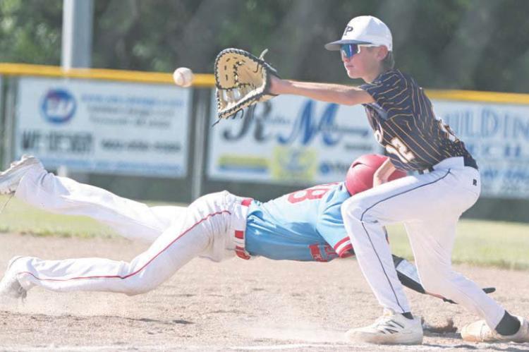 ST. PAUL’S TY HAAK attempts to tag out a baserunner in the St. Paul Juniors’ first-round game against Pender. Haak went one-for-three at the plate in the game, scoring two runs and driving in another. Photos by Michael Happ