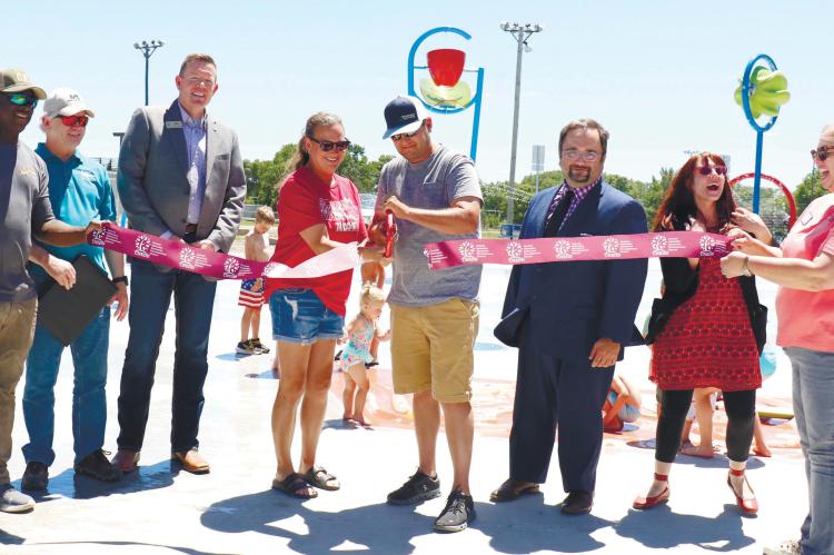 CUTTING THE RIBBON on Wolbach’s new playground and splash pad project last Thursday were Mario Robinson, Larry Steele, Josh Jelden, Shelby Steenson, Matt Steenson, Jerad Reimers, Chelsea Egenberger, and Carla Kimball. Photo by Michael Rother