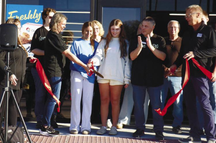 MEMBERS OF THE SCHWARTZ FAMILY cut the ribbon at Home Plate Market on Tuesday morning. Pictured cutting the ribbon are Liz, Ava, Perry, and Blake, and (back right) Dwayne Schwartz. Representatives with Associated Wholesale Grocers held the ribbon during the event. Photo by Michael Rother