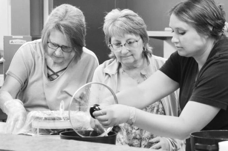 VOLUNTEERS with the Sts. Peter and Paul Council of Catholic Women, including Barb Sack, Charlene Potter, and Tonya Anderson, work to prepare meals during Lunch Bunch last Tuesday. Photos by Michael Rother