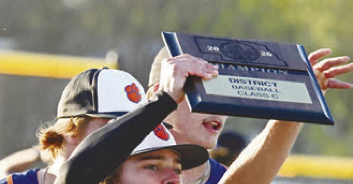 THE ST. PAUL/PALMER CATS had plenty to celebrate after knocking off Malcolm 15-13 in the District C-1 Championship game on Friday night. Above, Zandyn Weller hoists the championship plaque. Photo by Michael Happ