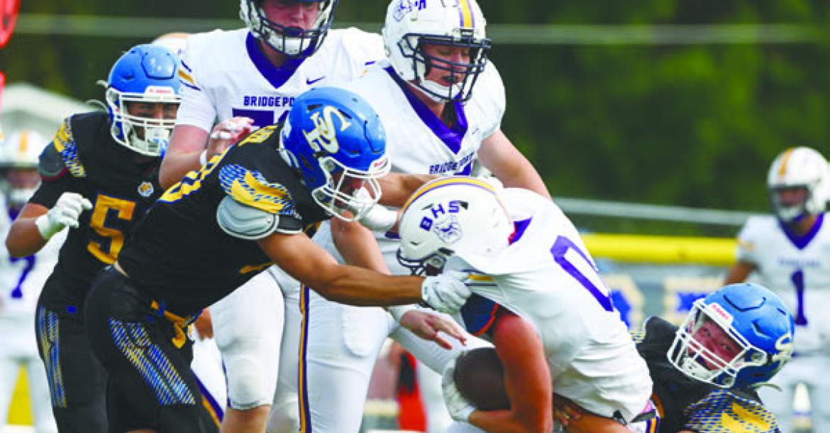 ST. PAUL’S COLTON KUSZAK AND JOEL KASLON work to bring down Daxton Malcolm during last Friday’s game against Bridgeport. Photo by Michael Happ