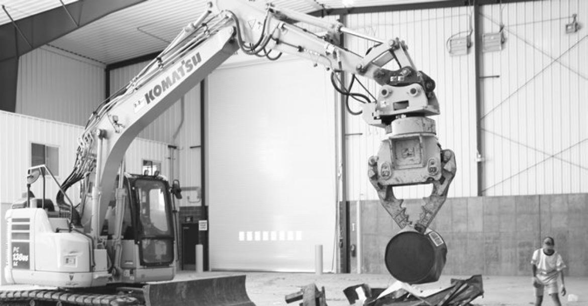 THE PICKER— which the Loup Central Landfill association uses to sort recyclable metal scrap from forms of municipal waste—is able to pick up all manner of scrap, from thin wire to engine blocks. Above, Kim Jensen uses the apparatus to pick up a steel drum while Brendan Muller sorts through material by hand in the background. Photo by Michael Rother