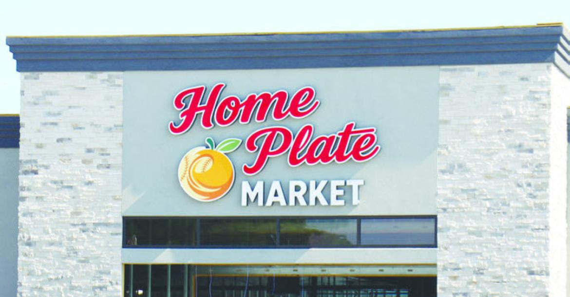 WORKERS officially put a name to St. Paul’s new grocery store over the weekend, as signage was hung on the future site of Home Plate Market on the corner of Second and O streets in St. Paul. The market, which is set to open late this fall, went ver tical at the start of the year. Crews have been working on the project since last fall. Photo by Michael Rother