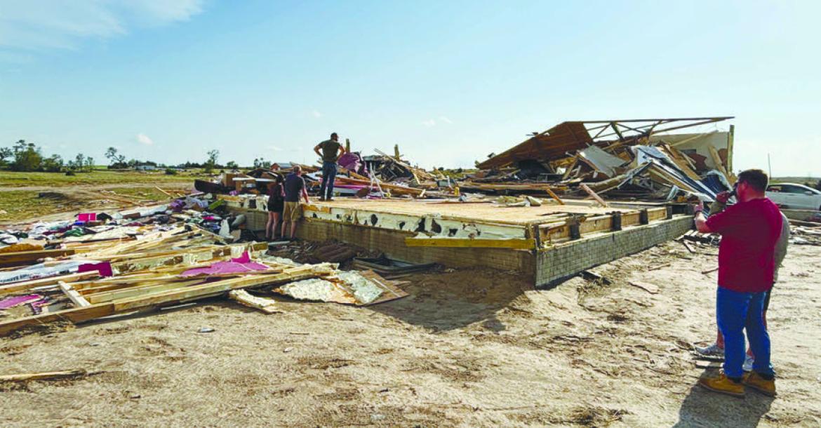 INDIVIDUALS SURVEY DAMAGE to a home at Denton Road and 7th Avenue earlier this week. A tornado caused damage to four homes in the area and across parts of Howard County on Sunday afternoon. Courtesy Photo