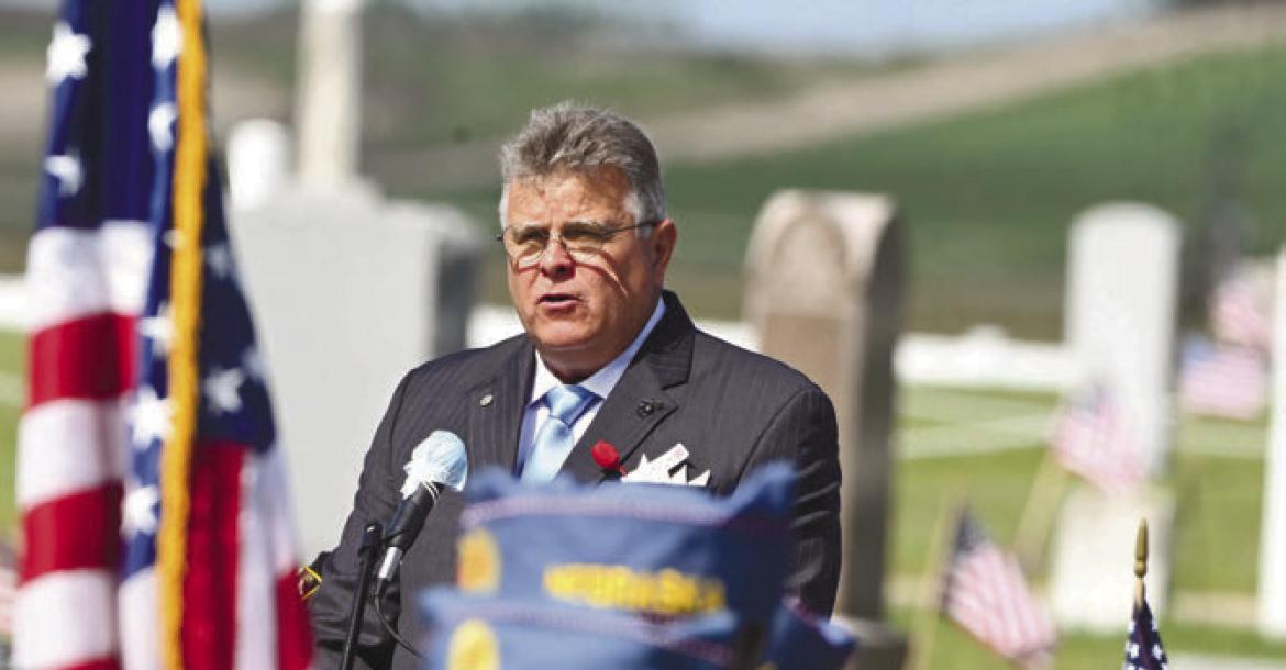 MEMORIAL DAY was observed at Elmwood Cemetery in St. Paul on Monday, with services being conducted by the Carl Mogensen American Legion Post 119, American Legion Auxiliary Unit 119, and the Sons of the American Legion. Above, George K. Szatko, Jr., a retired member of the United States Marine Corps, delivers the Memorial address. Photo by Michael Rother