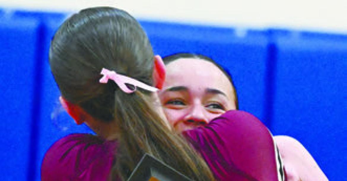 CENTURA’S TAYA TAUKIUVEA embraces Kennedy Davis after the Centura volleyball team won a five-set match over St. Paul to claim the school’s first-ever LouPlatte Conference Volleyball Championship last Thursday night. Photo by Michael Happ