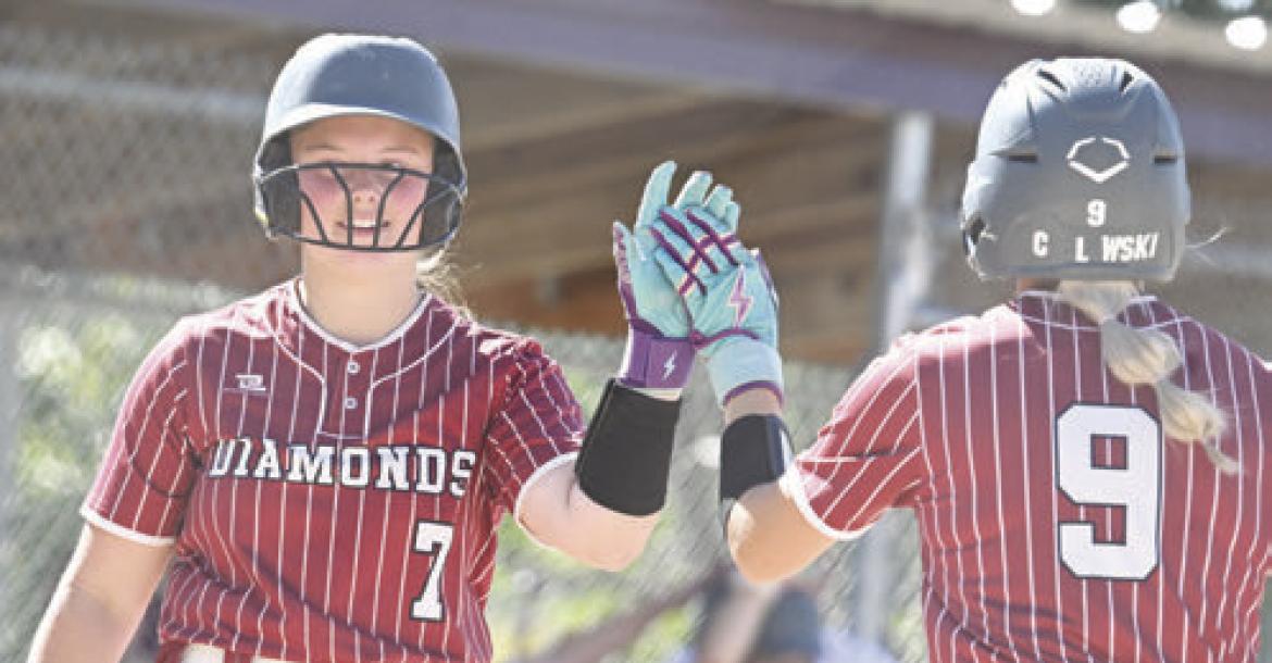 CALLEIGH SUNDBERG gives a high five to Lucy Chelewski during the Diamonds’ district final game in Cairo earlier this month. Centura/Central Valley lost both of their games at the NSAA Class C State Softball Tournament last week. Photo by Michael Happ