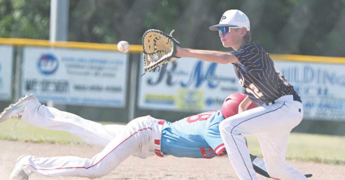 ST. PAUL’S TY HAAK attempts to tag out a baserunner in the St. Paul Juniors’ first-round game against Pender. Haak went one-for-three at the plate in the game, scoring two runs and driving in another. Photos by Michael Happ